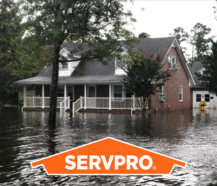 Pictured is a house that is surrounded by water after a flood. 